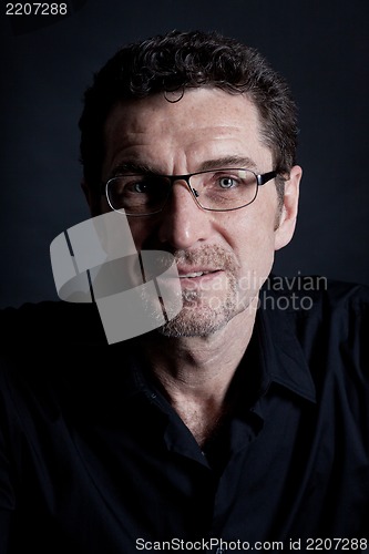 Image of attractive adult man with glasses on black background