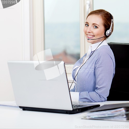 Image of smiling young female callcenter agent with headset