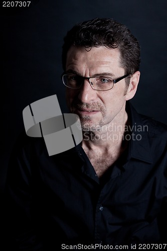 Image of attractive adult man with glasses on black background