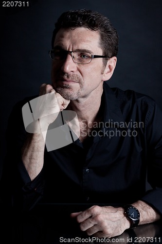 Image of attractive adult man with glasses on black background