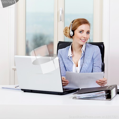 Image of smiling young female callcenter agent with headset