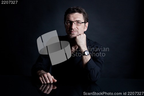 Image of attractive adult man with glasses on black background