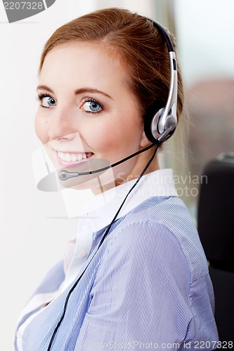 Image of smiling young female callcenter agent with headset