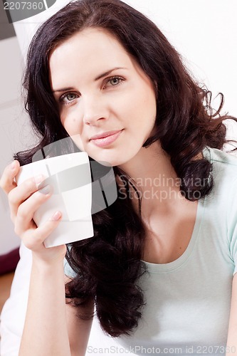 Image of smiling brunette woman drinking black coffee