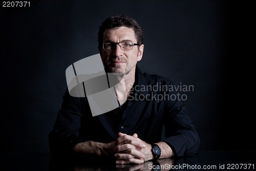 Image of attractive adult man with glasses on black background