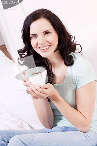 Image of smiling brunette woman drinking black coffee
