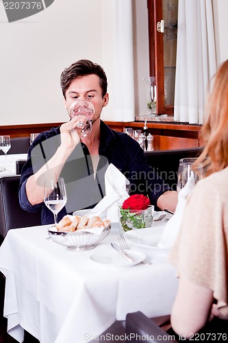 Image of couple drinking red wine in restaurant