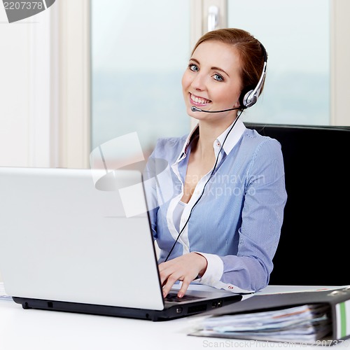 Image of smiling young female callcenter agent with headset