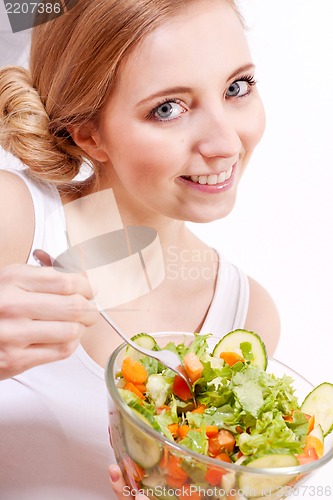 Image of smiling woman eating fresh salad