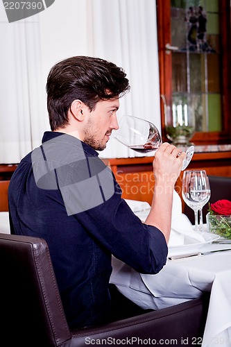 Image of couple drinking red wine in restaurant