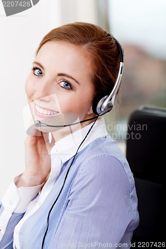 Image of smiling young female callcenter agent with headset