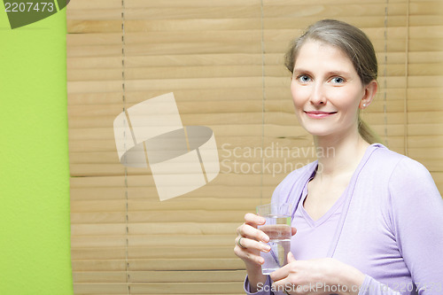 Image of A young attractive woman holding a glass