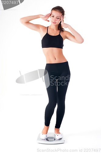 Image of happy young woman on weight scales