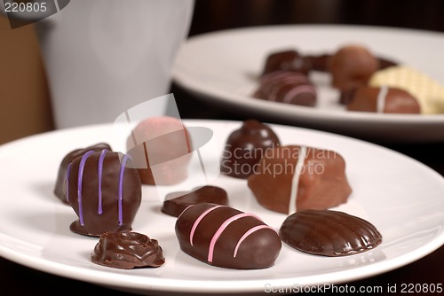 Image of Close up of two plates of chocolates with a cup of hot chocolate