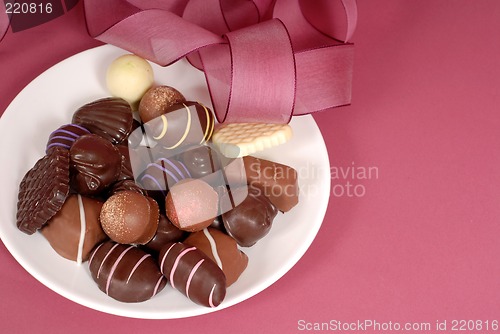 Image of Plate of delicious dark and semi-sweet chocolates with pink ribb