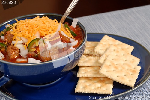 Image of Bowl of spicey chili and crackers with a spoon