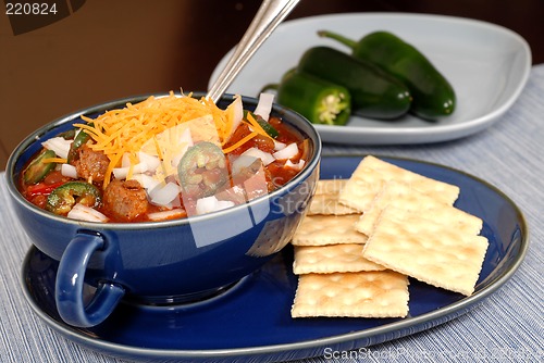 Image of Bowl of spicey chili and crackers with jalapeno peppers