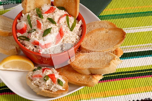 Image of Bowl of crab dip with toasted crostini and lemon