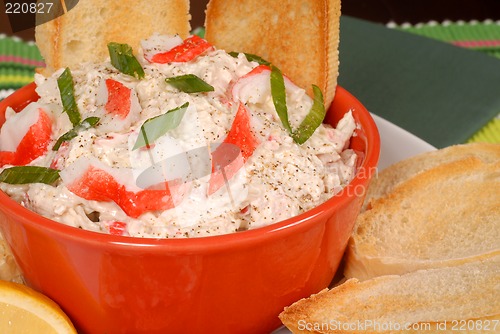 Image of Closeup of a bowl of crab dip with toasted crostini and lemon