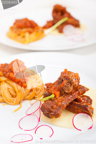 Image of pasta with pork ribs sauce on polenta bed