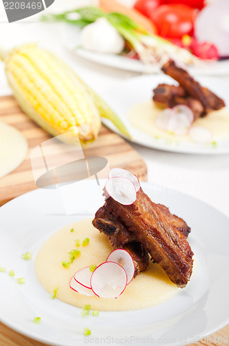 Image of pork ribs on polenta corn cream bed