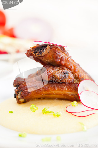 Image of pork ribs on polenta corn cream bed