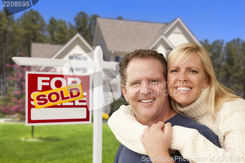 Image of Couple in Front of Sold Real Estate Sign and House