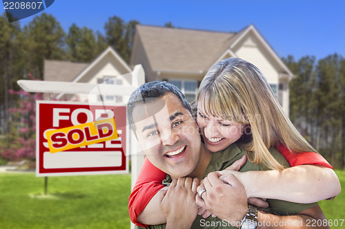 Image of Couple in Front of Sold Real Estate Sign and House