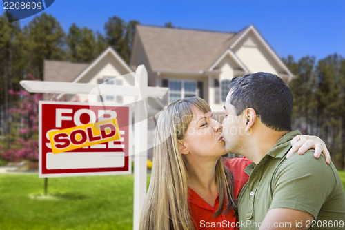 Image of Couple in Front of Real Estate Sign and House