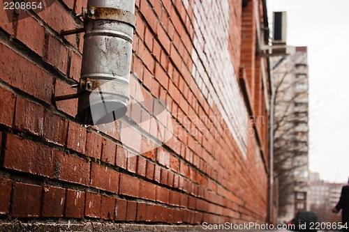 Image of black tube on a brick house wall (drain water)