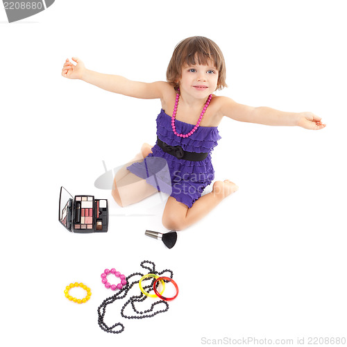 Image of Cute little girl with makeup, necklaces and bracelets is in adul