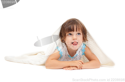 Image of Little girl lying on the floor wrapped in a light blanket and to