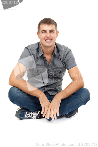 Image of casual man sitting in lotus position, smiling