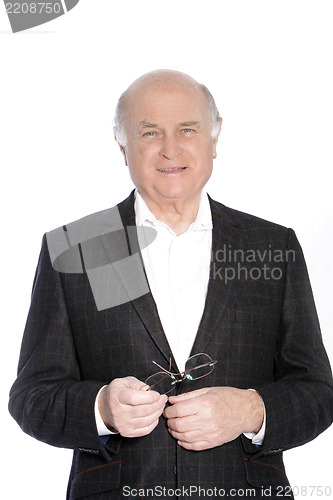 Image of Smiling pensioner holding his glasses