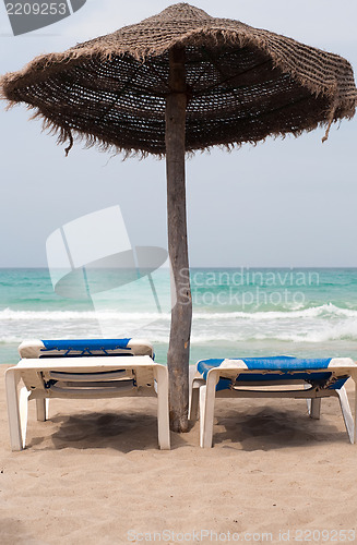 Image of Two chaise longes on the beach