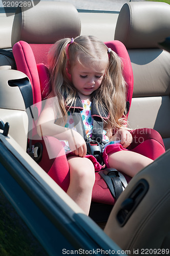 Image of Little cute girl sitting in car seat