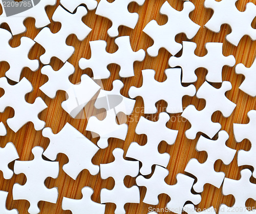 Image of white jigsaw puzzle on wooden background