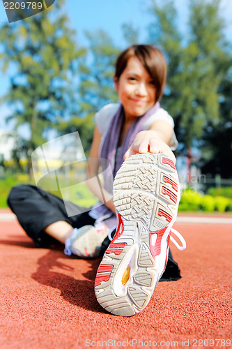 Image of woman doing stretching exercise in park