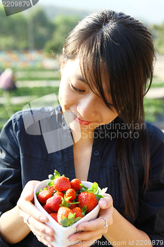 Image of smile girl with bowl of strawberry