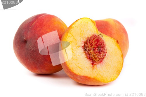 Image of Three tasty juicy peaches with a half  on a white background