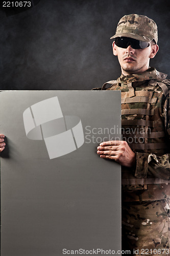 Image of Modern soldier is holding a poster