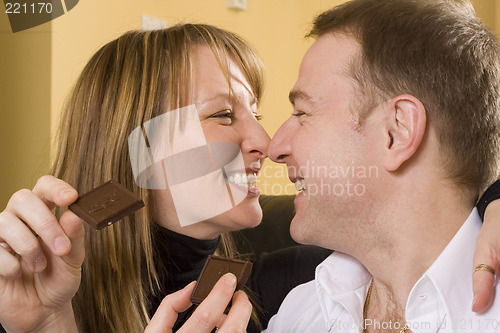 Image of couple on couch eating chocolate