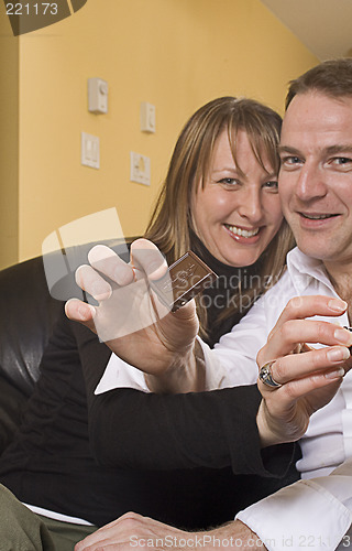 Image of couple on couch pointing out chocolate