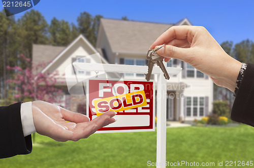 Image of Agent Handing Over the House Keys in Front of New Home