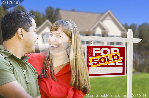 Image of Couple in Front of Sold Real Estate Sign and House