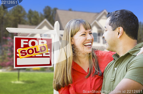 Image of Couple in Front of Sold Real Estate Sign and House