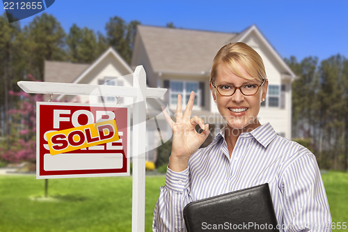 Image of Real Estate Agent in Front of Sold Sign and House