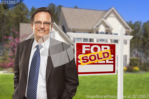 Image of Male Real Estate Agent in Front of Sold Sign and House