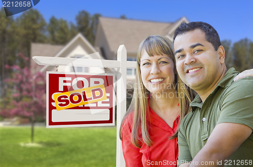 Image of Couple in Front of Sold Real Estate Sign and House