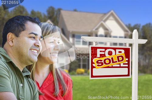 Image of Couple in Front of Sold Real Estate Sign and House